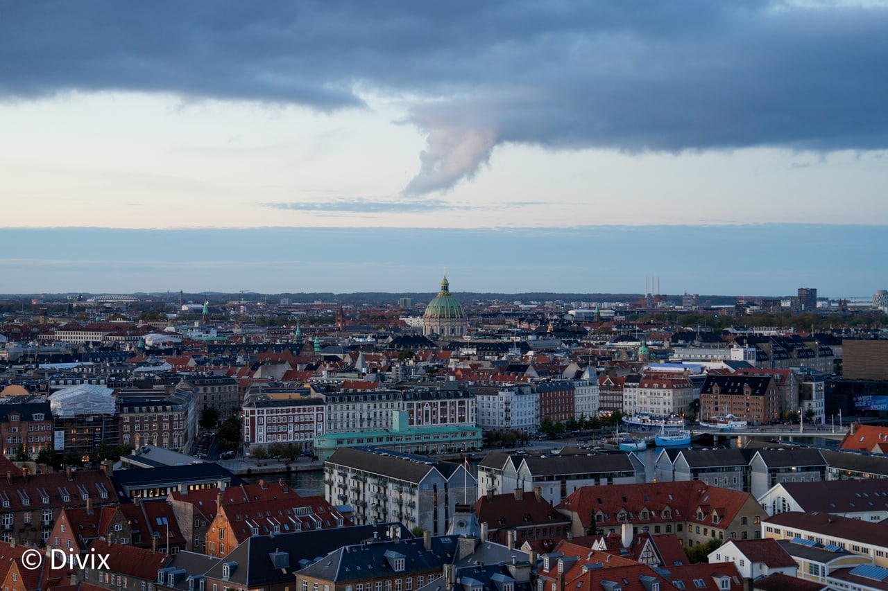 The Copenhagen skyline beneath layered blue storm clouds